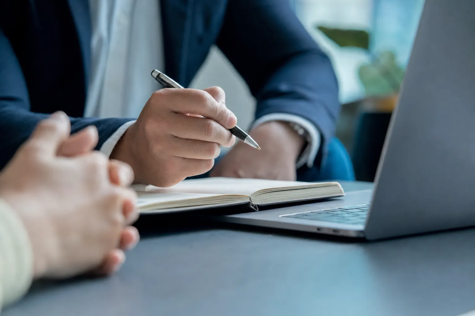 Notes being taken beside a laptop during an advisory session.